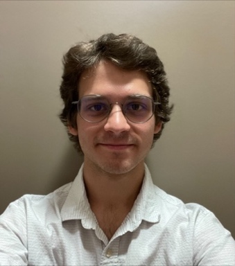A person wearing glasses and a white shirt Description automatically generated